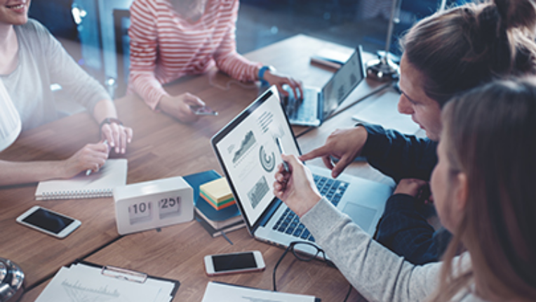 Group of people looking at a computer in an office